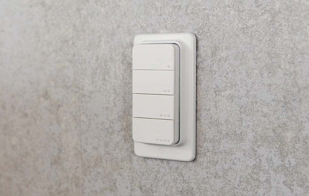 Smart remote control attached to a gray wall