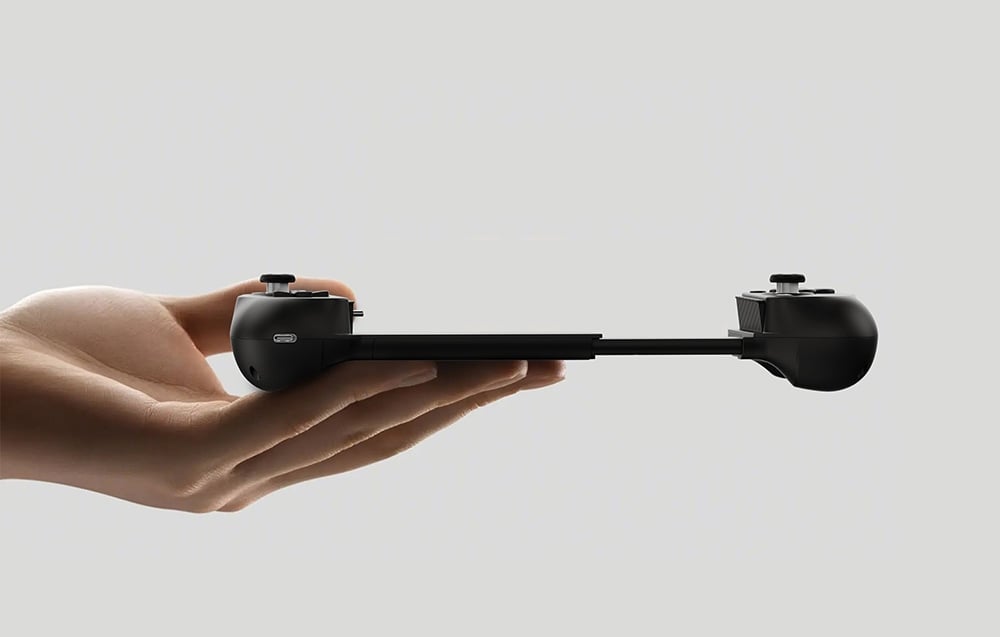 A black GameSir controller stretched in the hand, visible from the side against a gray background.