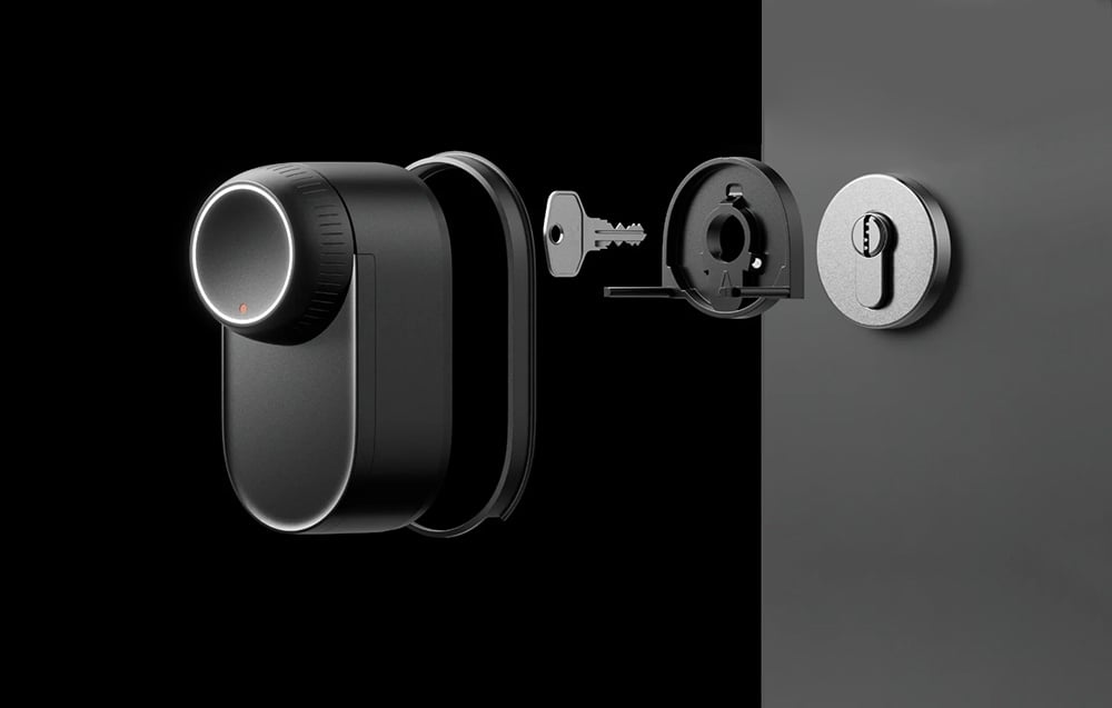 Disassembled SwitchBot lock - cylindrical unit with key, inner mechanism and outer cover