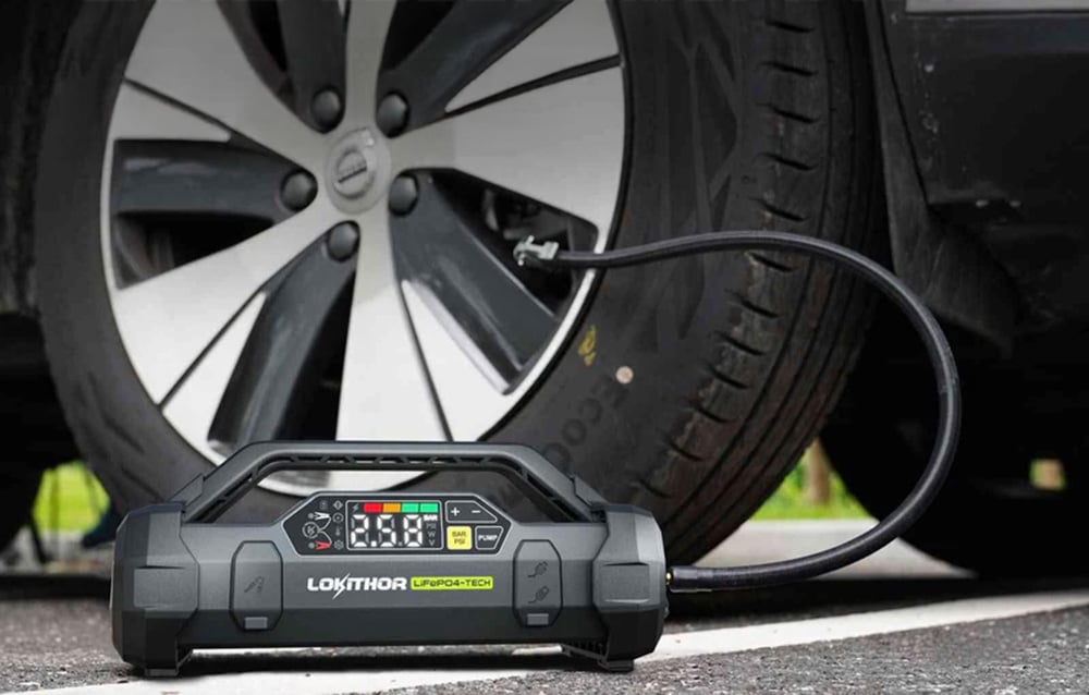 A multifunctional device inflating a tire in a modern car using a flexible hose.