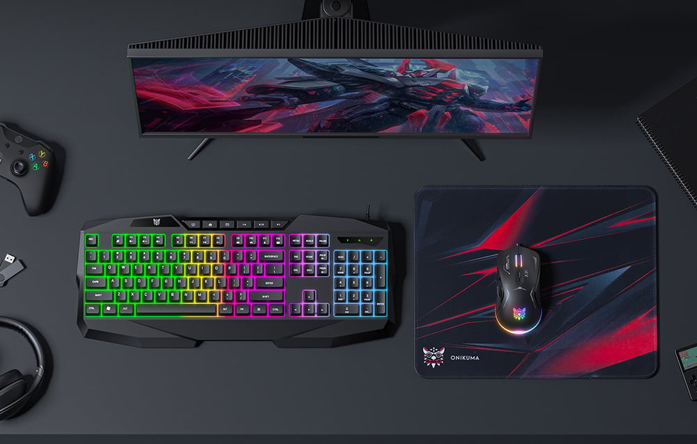 The keyboard, mouse, and mouse pad are on a dark desk next to the monitor
