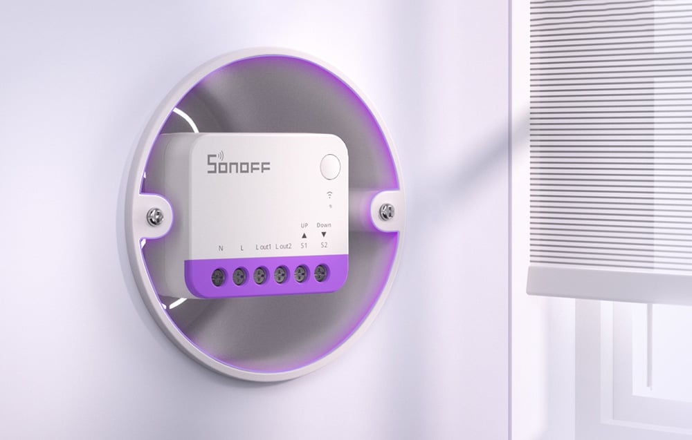 Close-up of a Sonoff module with purple housing mounted in a round frame on a white wall