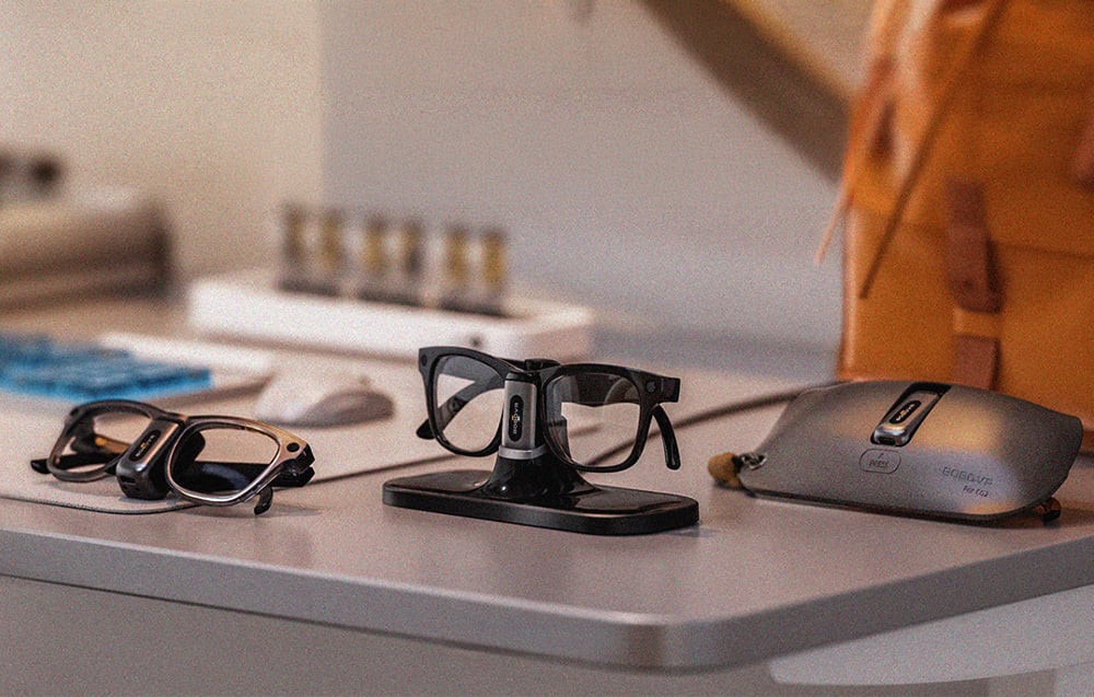 The BOBOVR CG2 charging system with glasses, docking station, mobile battery clip, and charging case displayed on a tabletop.