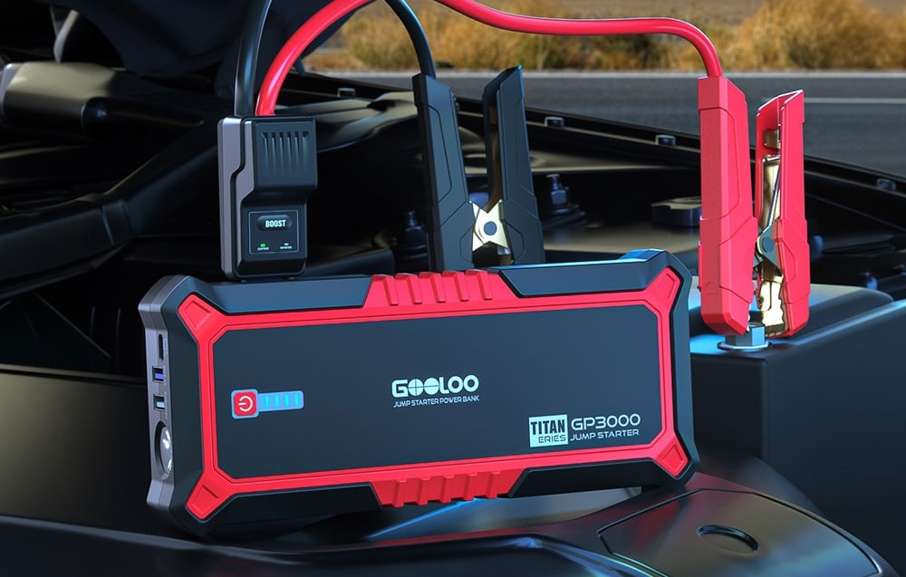 Car jump starter connected to a battery in the engine compartment