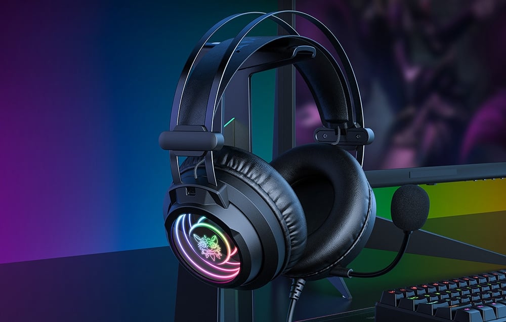 Gaming headphones with microphone on stand next to keyboard and monitor