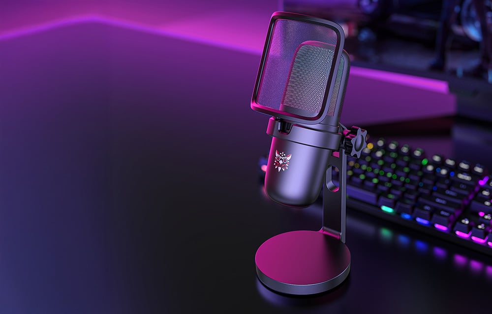 Black Onikuma gaming microphone on the desk, keyboard and monitor in the distance