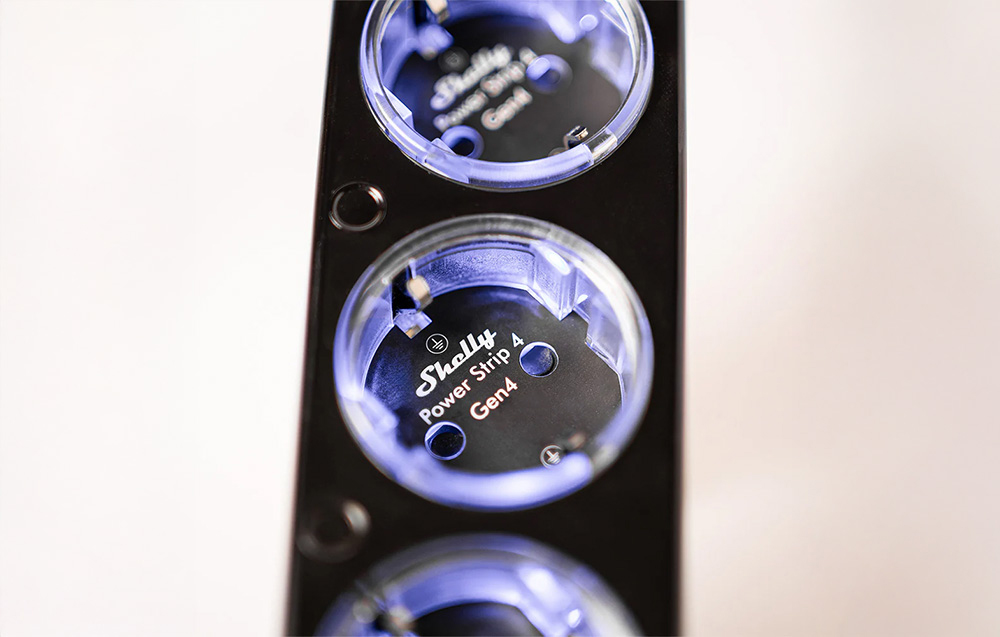 Close-up of the outlets of the Shelly Power Strip 4 Gen4 smart power strip with LED backlight.