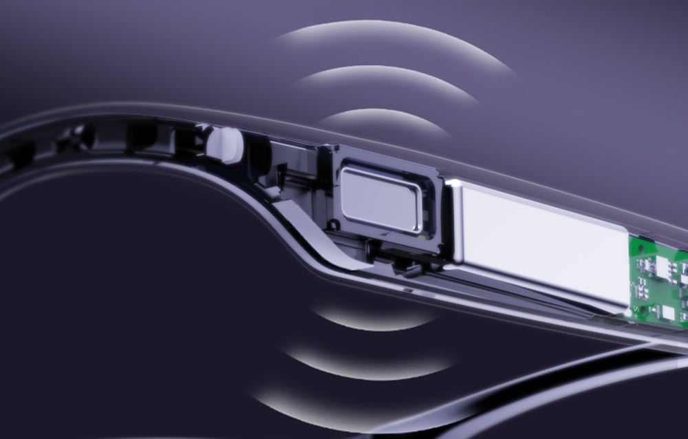 Close-up of the inside of a glasses temple with a visible speaker and sound waves.