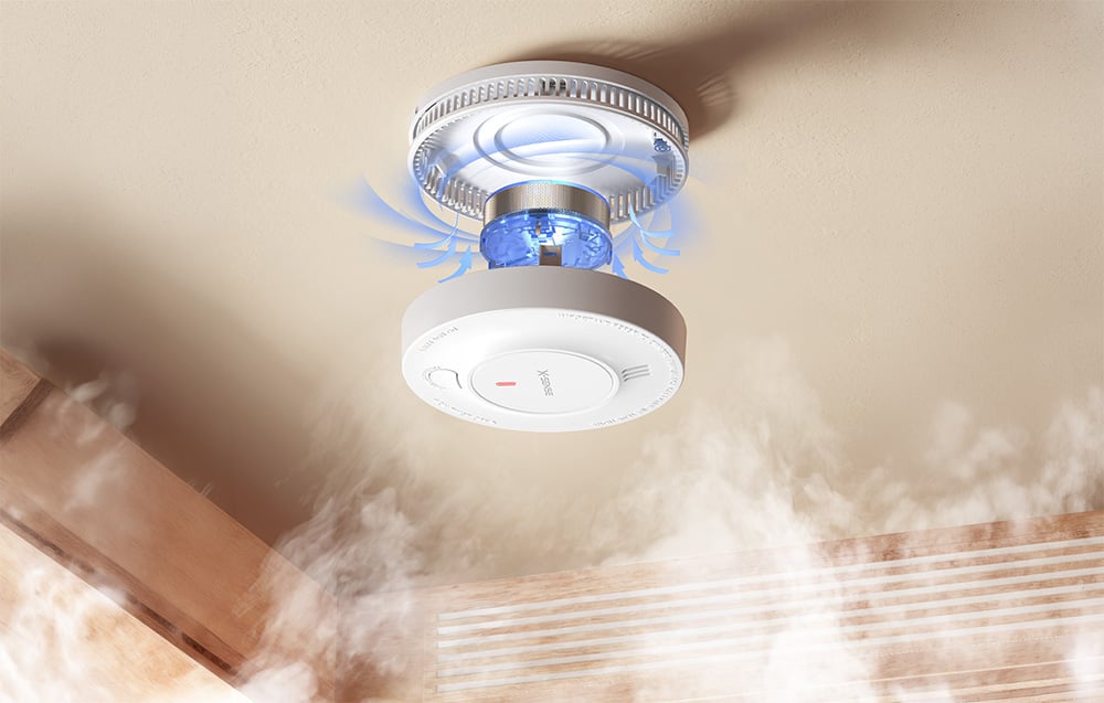 X-Sense smoke detector mounted on the ceiling with smoke and a blue light effect