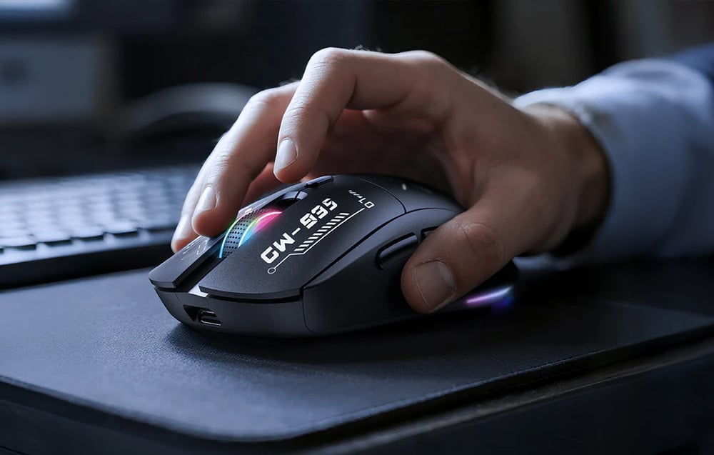 Hand using a black mouse on a dark desk