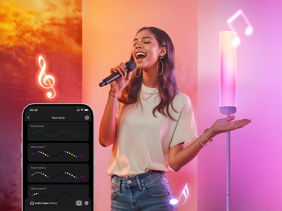 A woman singing into a microphone against the backdrop of a smartphone with a music app and a lamp glowing with pink light.