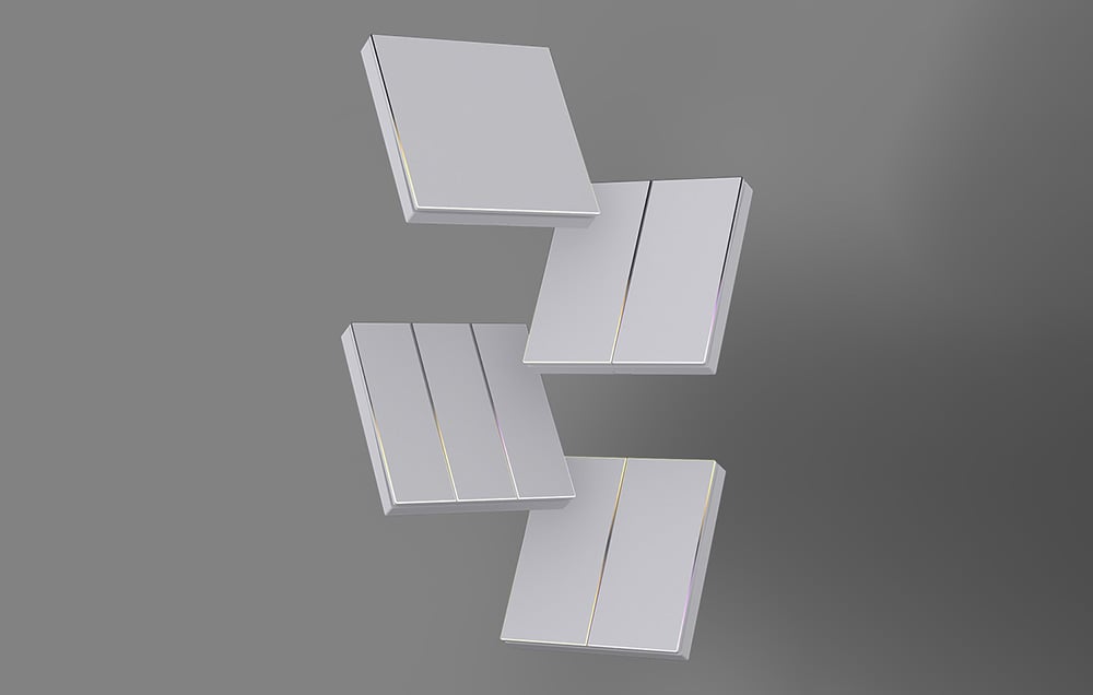 Four white heating panels with a subtle gold finish arranged on a gray background in a geometric pattern