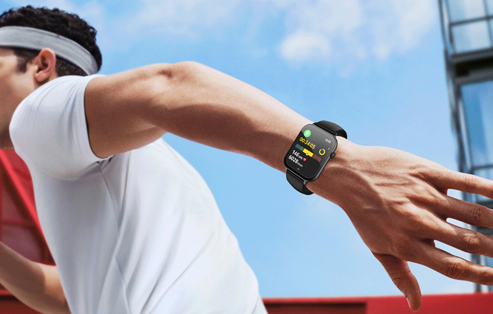 A man in a white T-shirt is running outdoors with a black Colmi smartwatch on his left wrist
