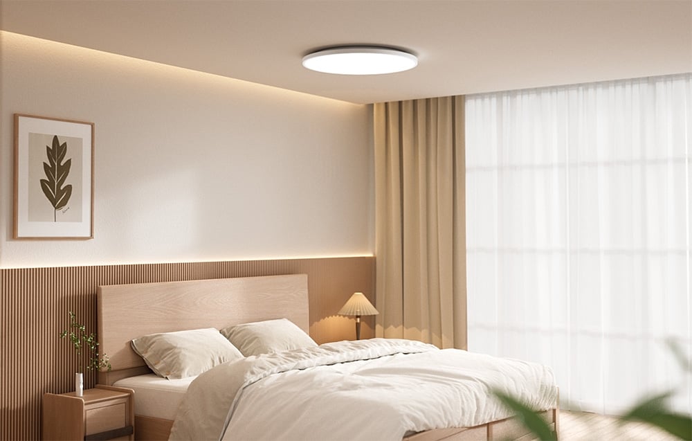 Bright bedroom with bed and Yeelight Mercury C300 ceiling mounted light on.