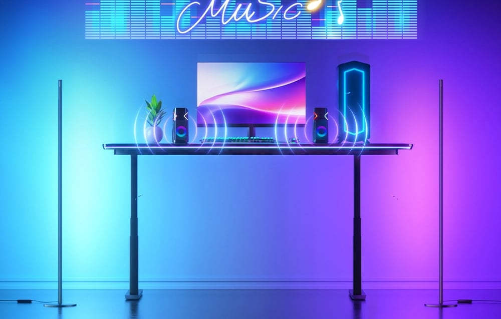 Gaming desk with RGB backlighting, monitor and speakers in blue-purple LED lighting