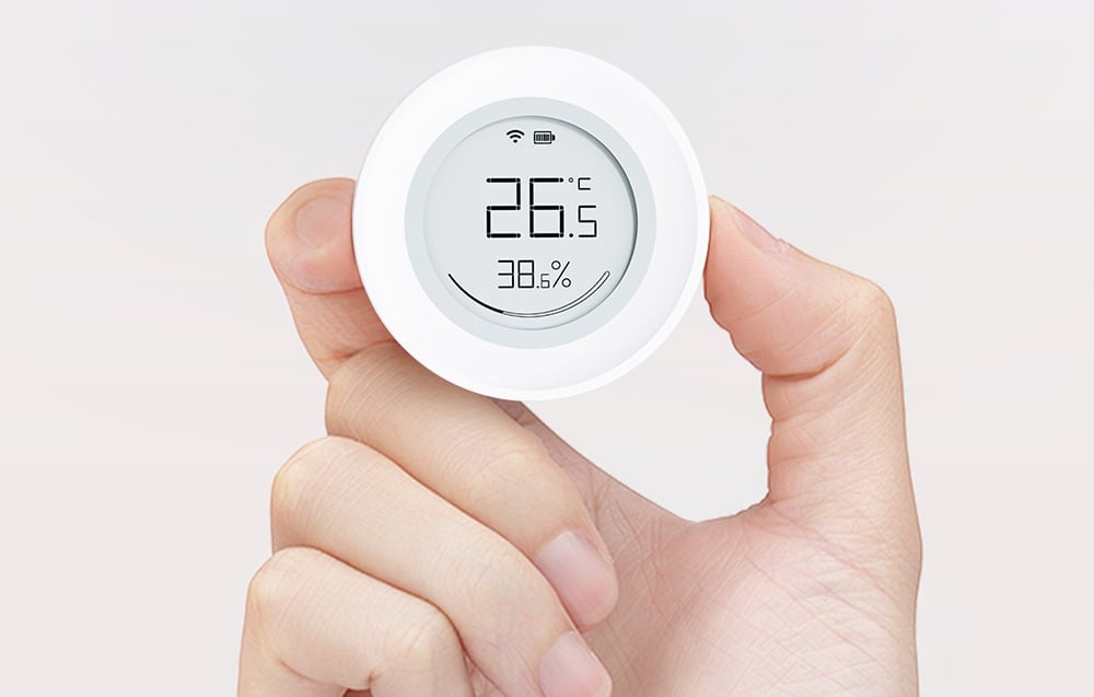 Sensor held in fingers, with temperature readings of 26.5°C and humidity of 38.6% displayed
