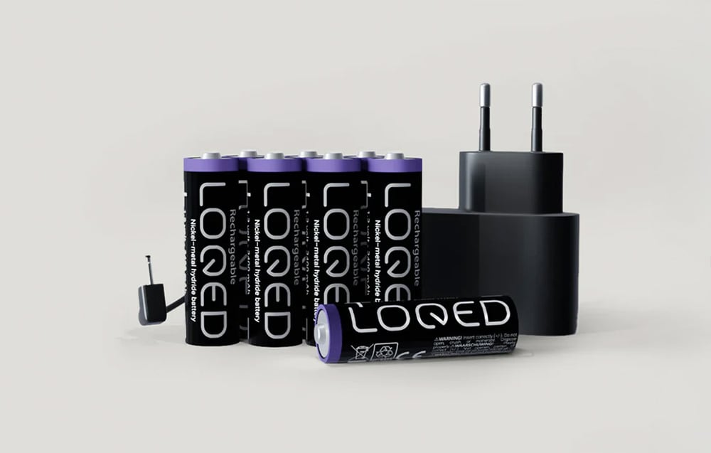 Set of eight batteries with LOQED lettering together with mains charger and cable on gray background