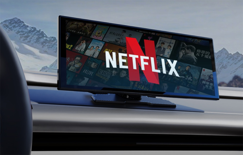 A car display with the Netflix logo against a backdrop of snow-capped mountains, mounted on the dashboard