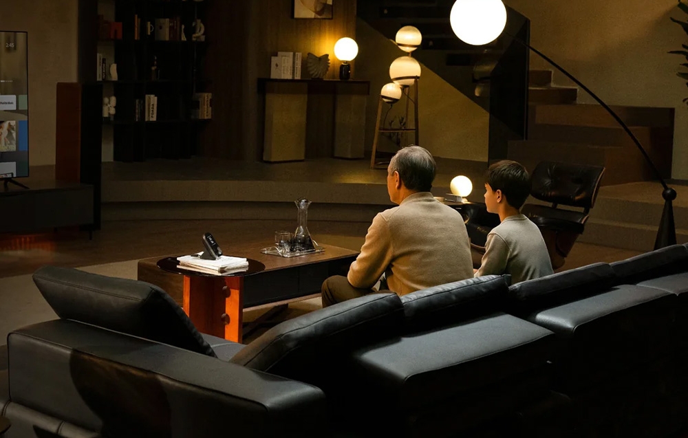 A couple watching TV in a cozy living room with elegant lamps and modern decor