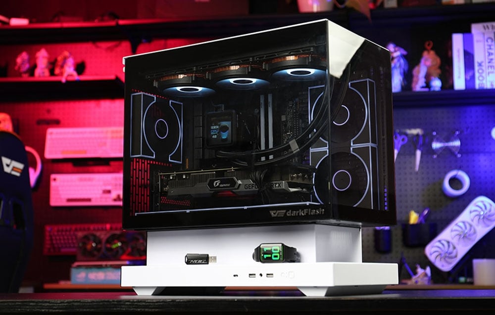 Computer case with transparent panels and white base on the background of a workshop with colored lighting