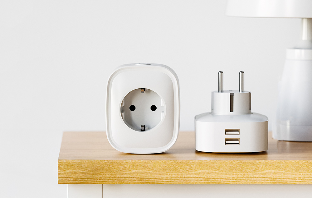 Two white adapters on the countertop—one with an electrical outlet, the other with two USB ports