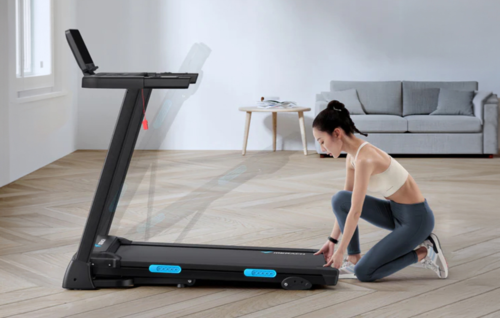 Woman folding Merach treadmill in spacious living room