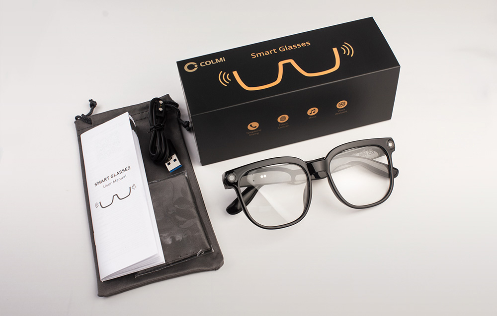 A set containing black glasses, a case, a user manual, a charging cable, and a decorative box.