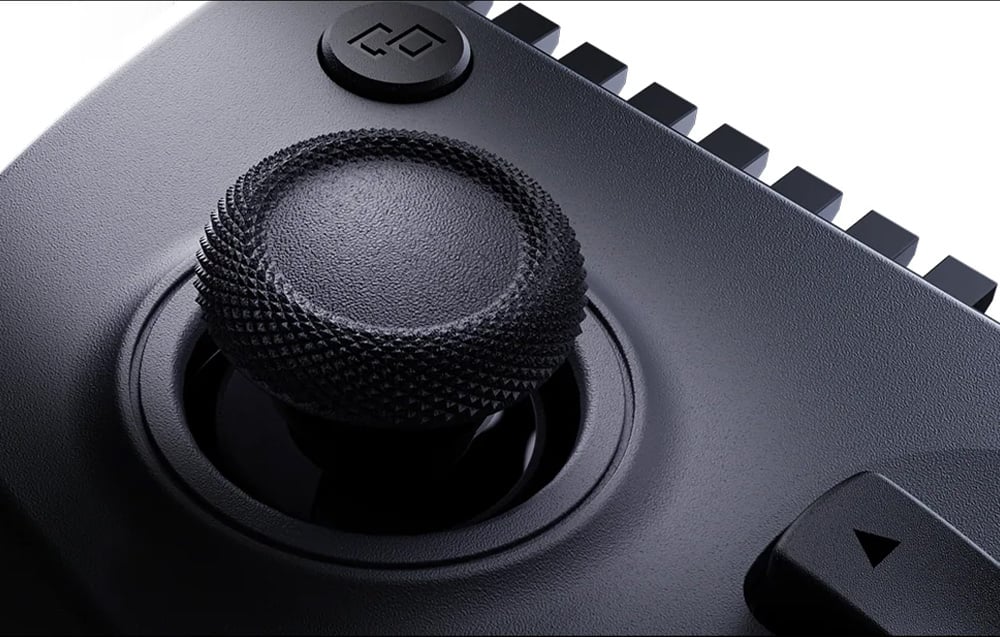 A close-up on the left analog stick of a controller with a textured surface