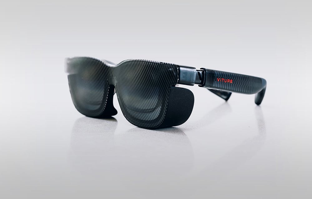 Black glasses with sun visor on a gray background