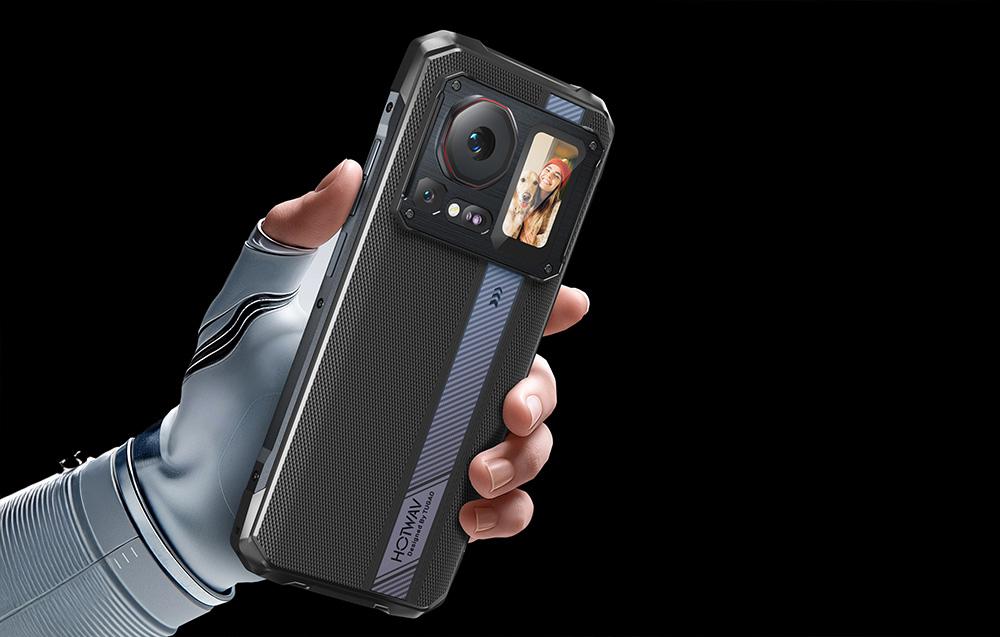A hand in a white glove holding a smartphone with a photo preview (selfie) displayed on the rear screen.