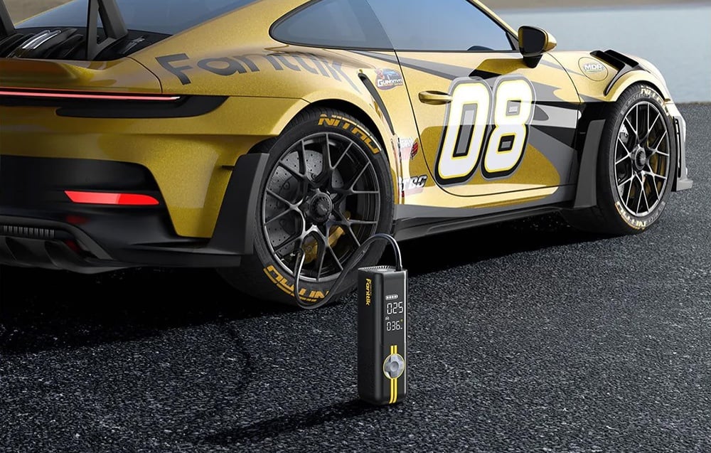 Yellow sports car stands parked with compressor connected to the tire.