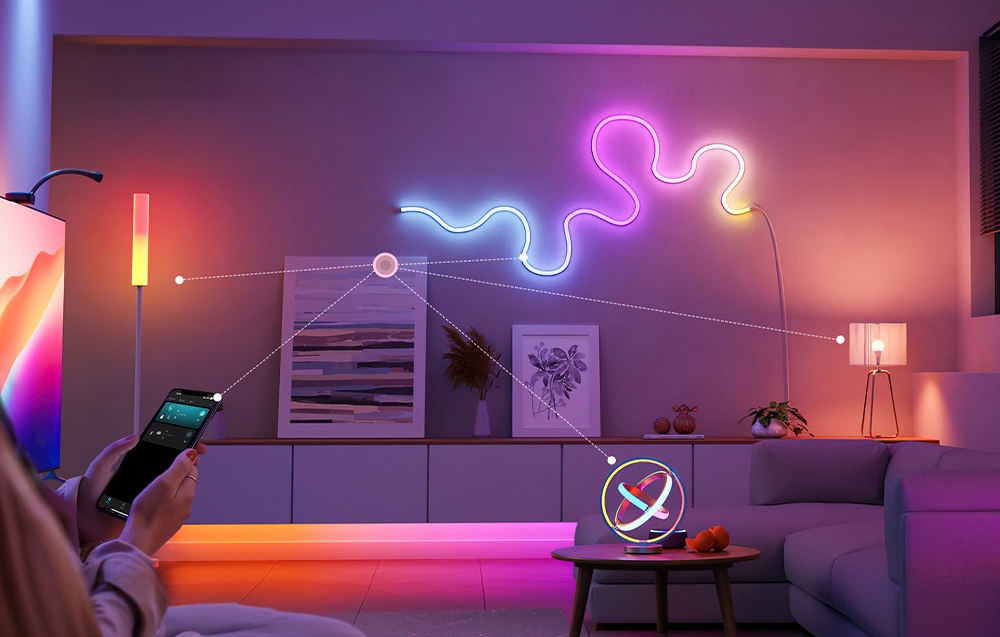 A modern living room with a sofa, wall lighting, and a small, round desk lamp standing on a coffee table.