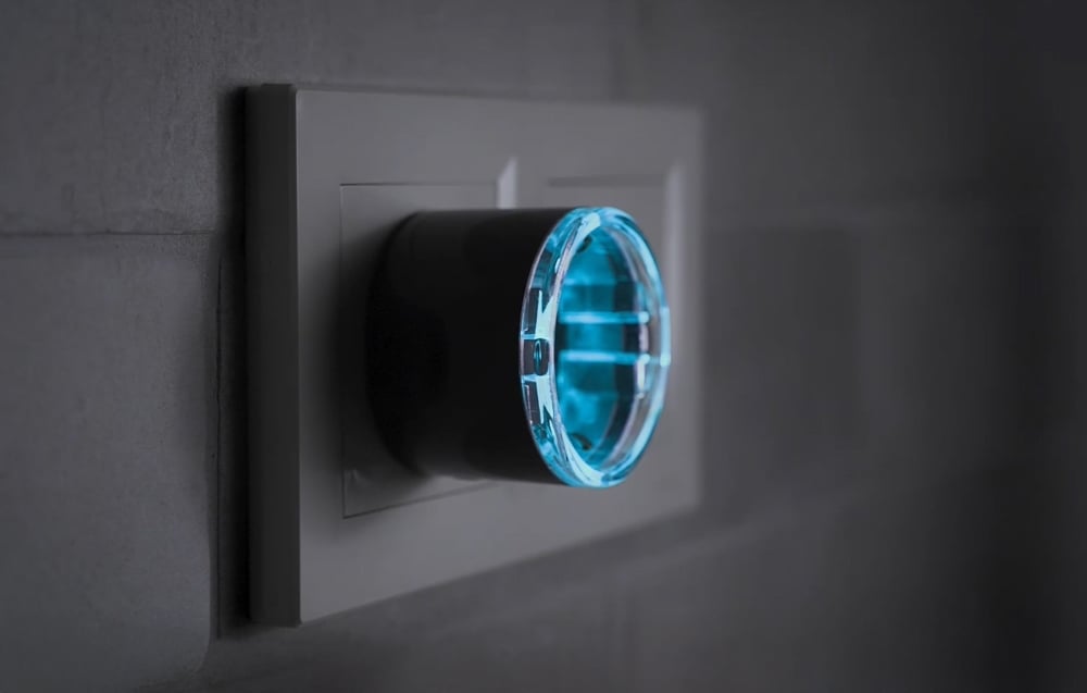 Side view of the connected Shelly Plug S with blue backlight protruding from the outlet