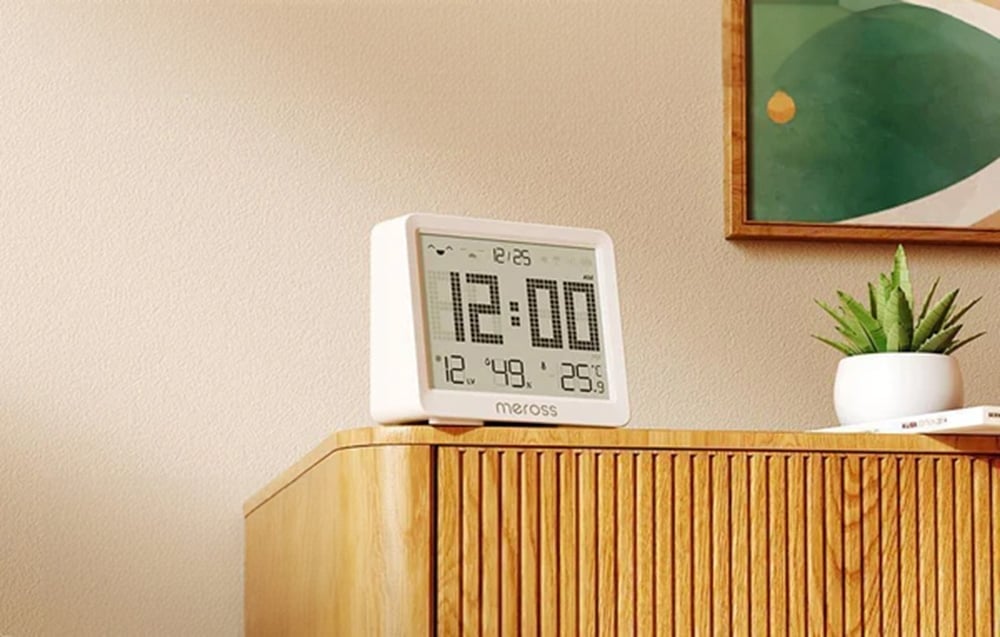 Meross digital clock with time, temperature and humidity display, standing on a wooden dresser