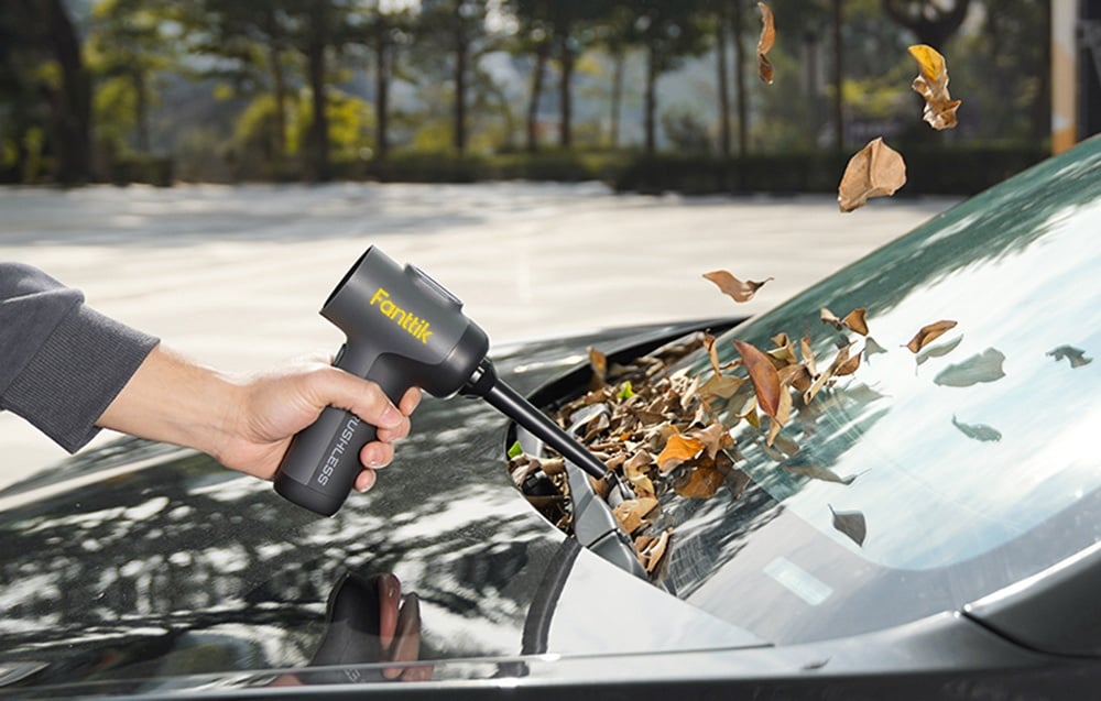 Leaves blown off the car window with the Fanttik portable vacuum cleaner.