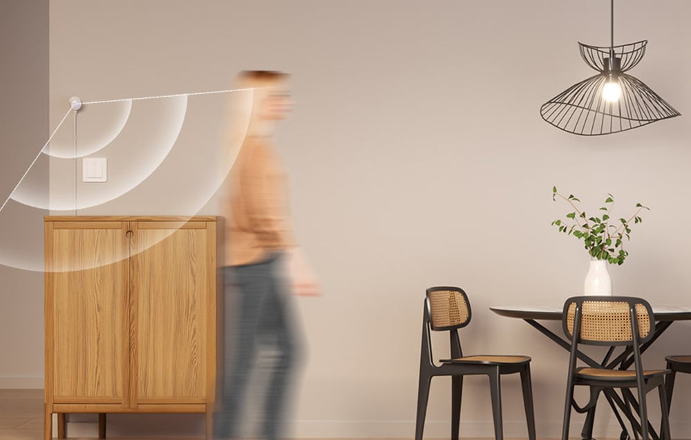 A person walking through a modern interior with a wooden dresser, rattan chairs and designer pendant lamps, with a graphic overlay illustrating signal coverage