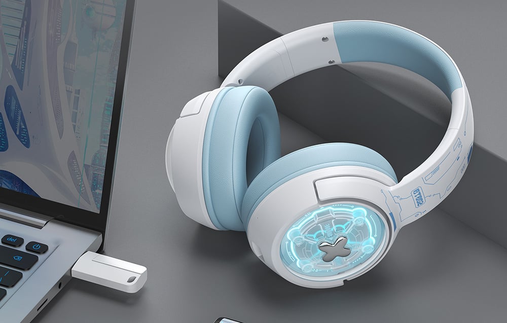 Gaming headphones standing next to a laptop to which an adapter is connected