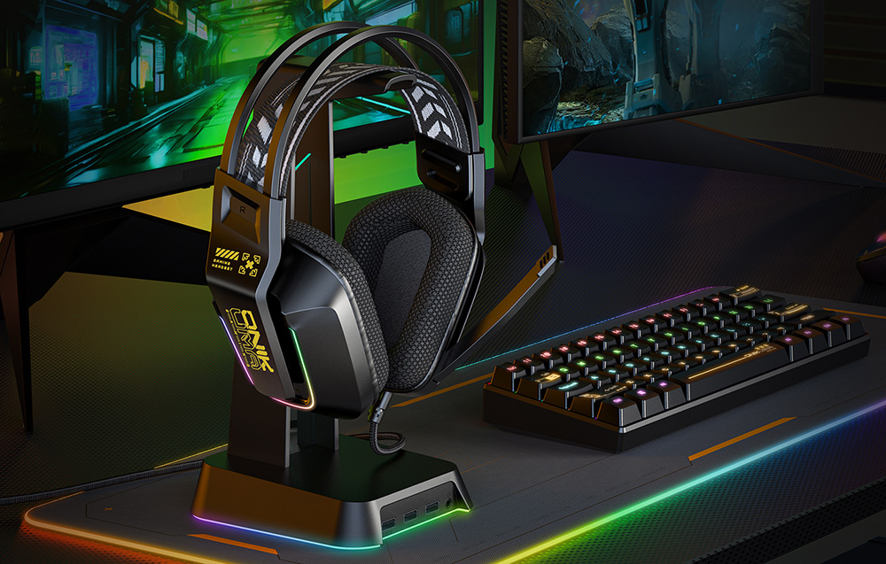 Onikuma gaming headphones hanging on a bracket next to a keyboard and monitor