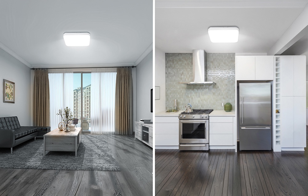 A gray living room and kitchen lit by white ceiling lights