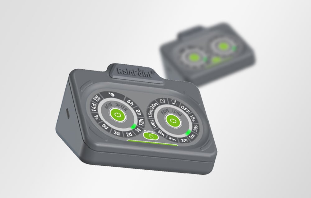 Two gray RainPoint® irrigation controllers on a light background, with the one in the foreground in focus and the one in the background blurred