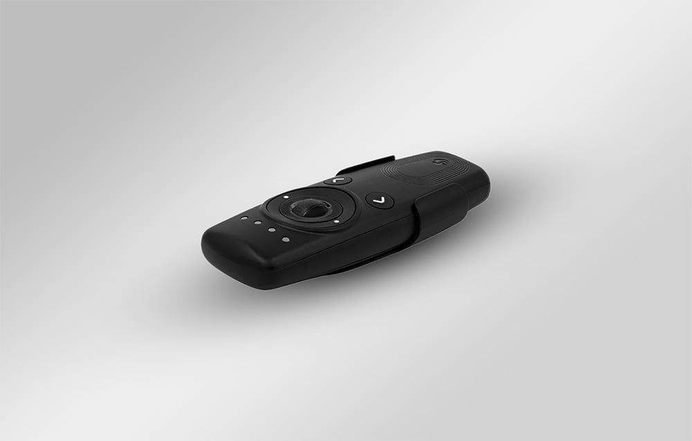 Shelly BLU remote control in a holder seen at an angle against a gray background, showing the side profile and layout of the elements