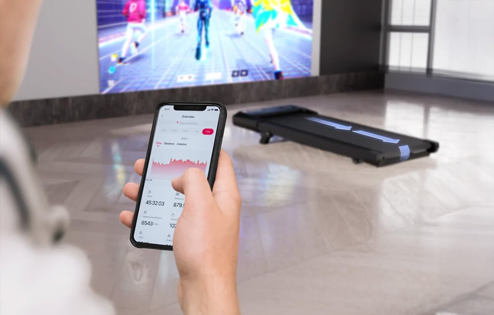 Hands holding a smartphone with a fitness app displaying workout stats and graphs