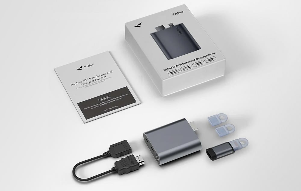 RayNeo set with adapter, adapters, HDMI cable and instructions, arranged next to the package on a bright background.