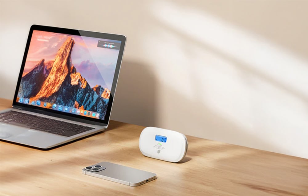X-Sense carbon monoxide detector set on a desk next to a laptop and smartphone