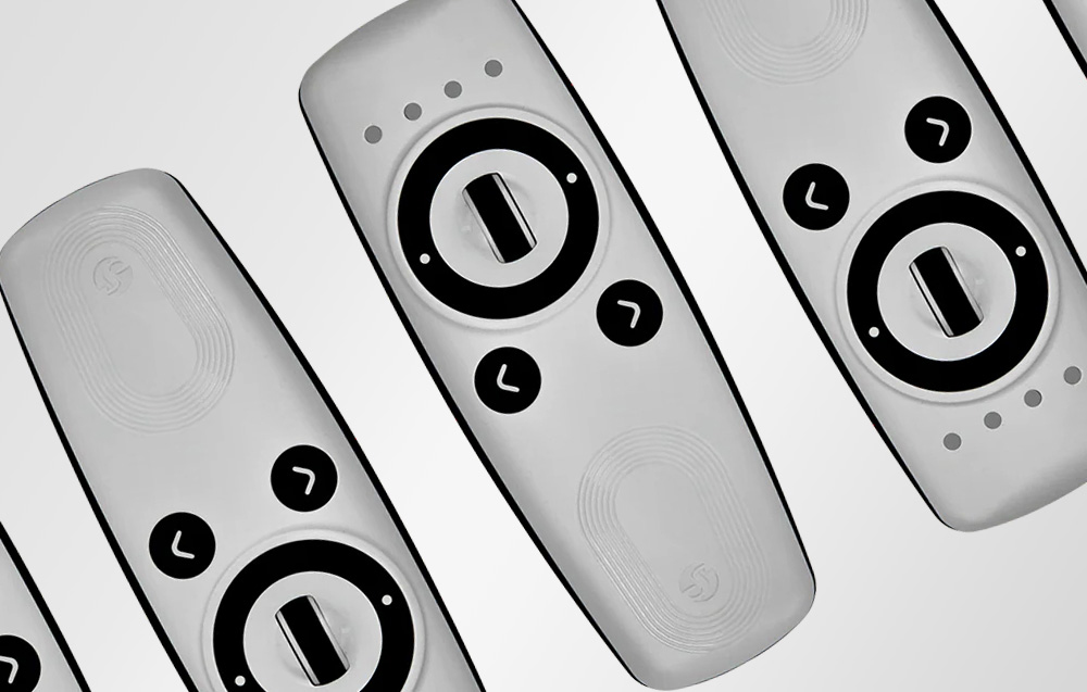 Four white Shelly remotes with black knobs and buttons, arranged diagonally on a light background.