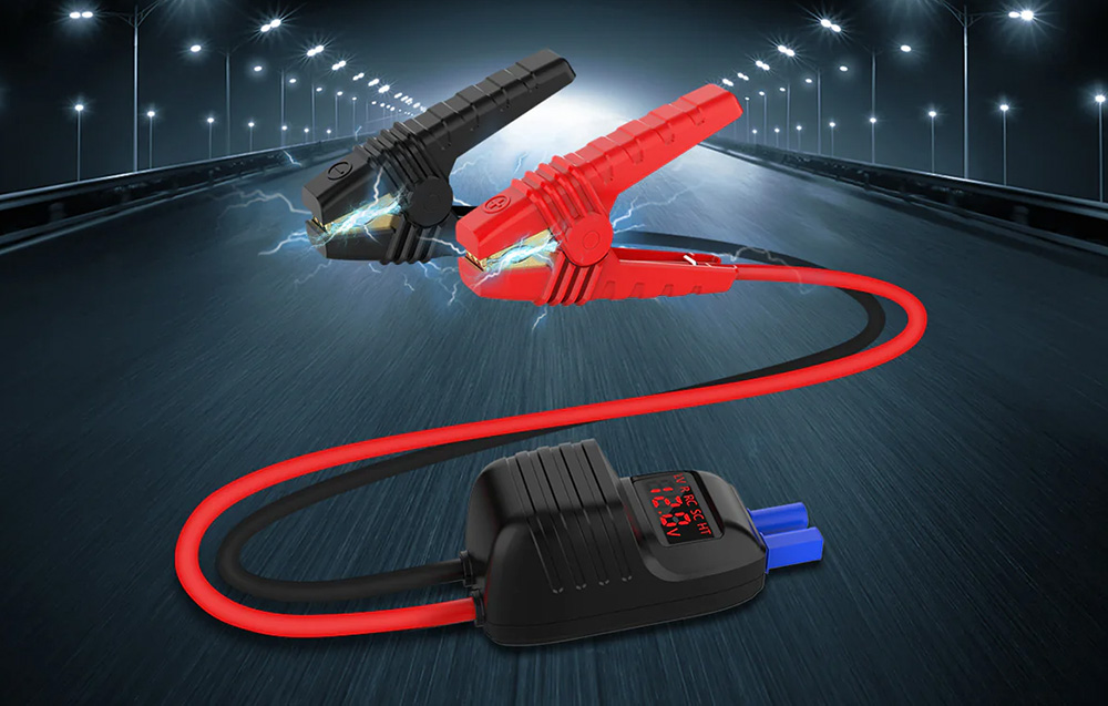 A black-and-red battery clamp with a cable and a small screen displaying the voltage.