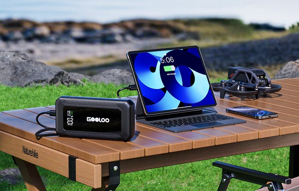 Starter charging a smartphone lying on a rock on the grass