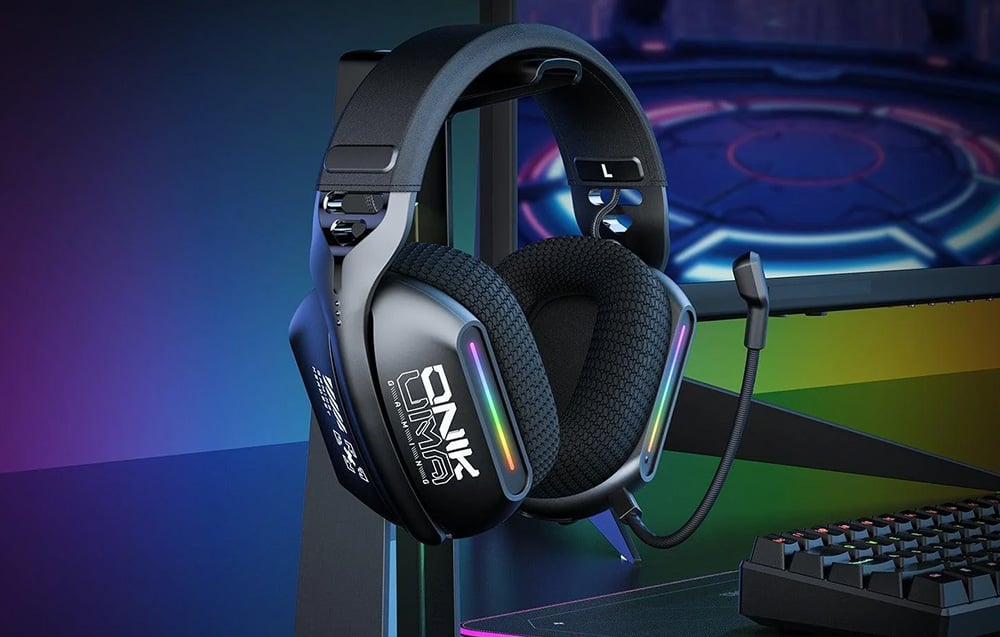 In-ear headphones hanging on a bracket, with a monitor and keyboard in the background