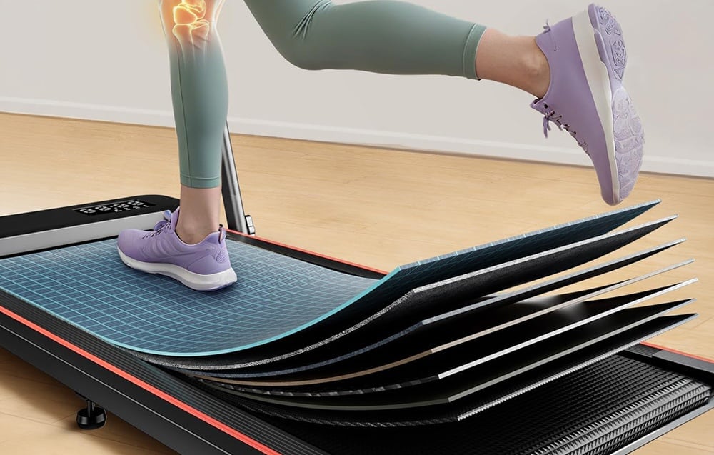 Close-up of the multi-layered running belt of a treadmill on which a person in green leggings and purple shoes is running