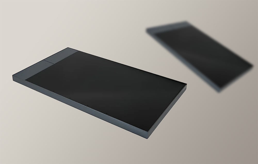 Two dark gray touch panels with screens off on a beige background